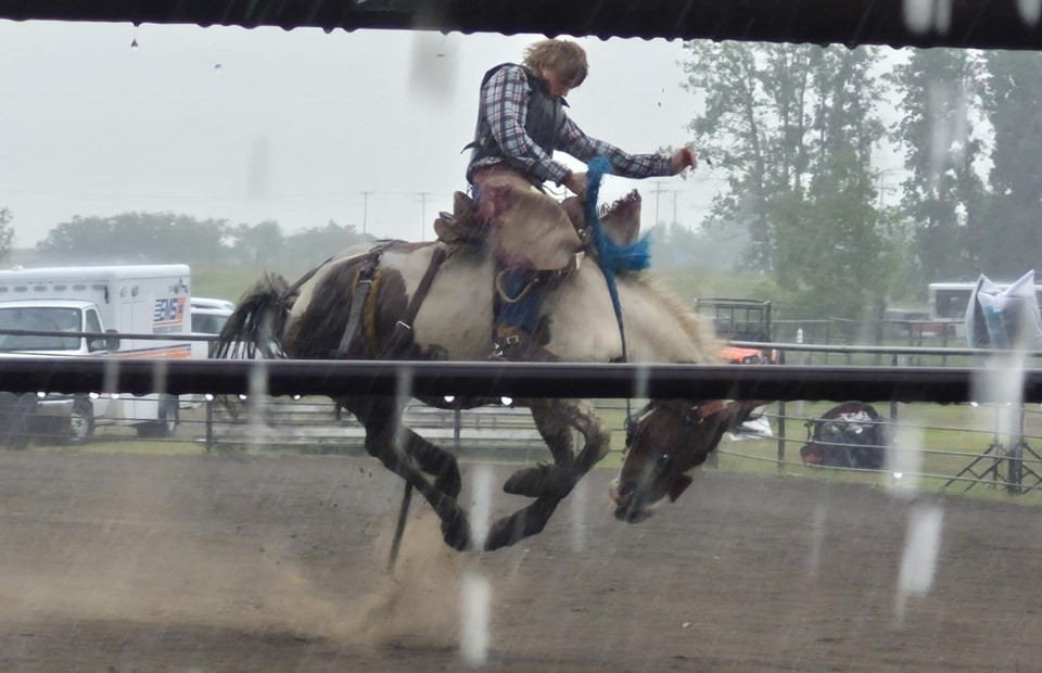 Even with the sudden downpour of rain, this bronc rider put in his eight seconds.