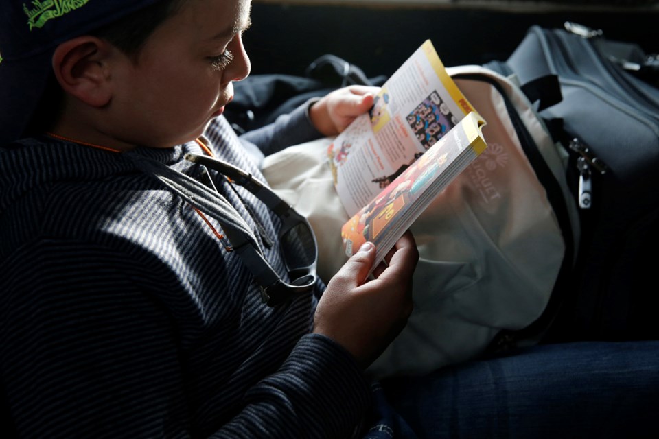 8-year-old boy reading in a car