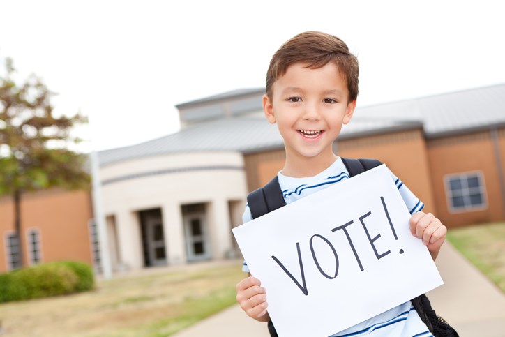 Elementary student holding vote sign