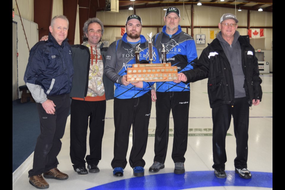 Glen Becenko of Kamsack, Duck Mountain Super League organizer, presented the championship trophy to team Pioneer Hybrid after the Canora foursome swept through the championship semifinal and final rounds at the Sylvia Fedoruk Centre in Canora on Jan. 10. From left, were: Becenko, Zeno Gulka (second), Brandon Zuravloff (skip), Rob Zuravloff (third) and Bob Kolodziejski (lead). 