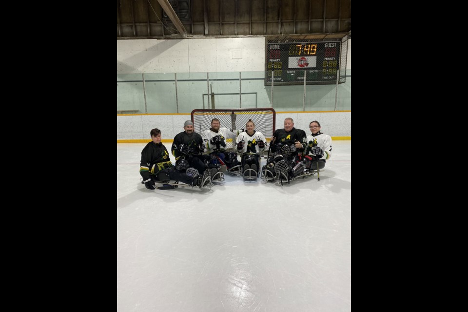 Some of the regular para hockey players line up for a team photo at Cut Knife arena.