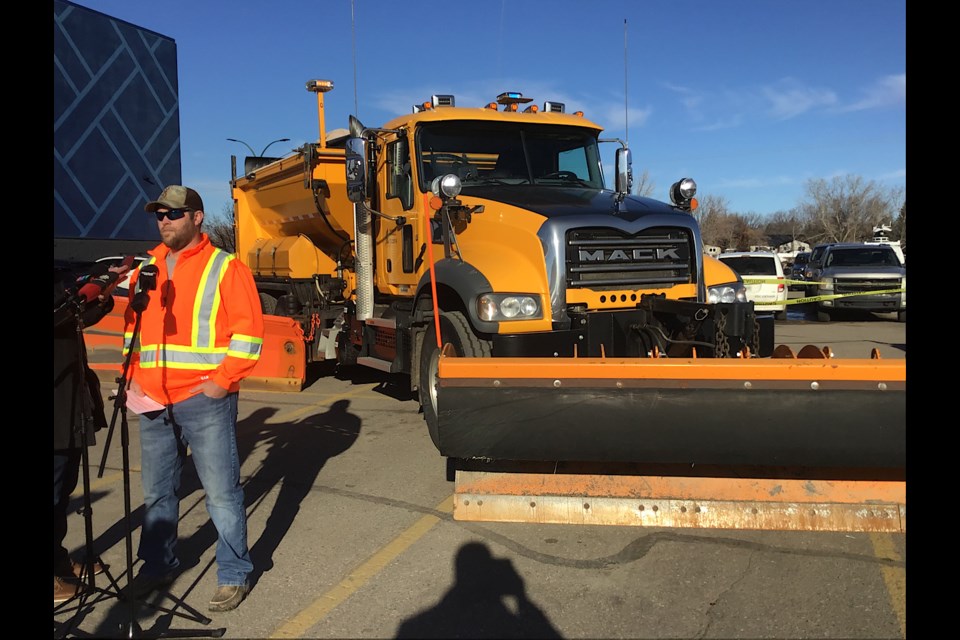 Snow plow operator Bryan Sherman speaks to reporters in front of the Ministry of Highways snow plow.