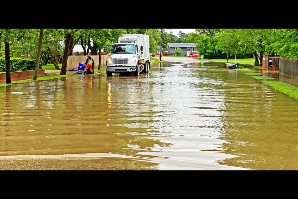The City of Weyburn's refuse truck made its way down a flooded street to pick up garbage after heavy rain the previous night.