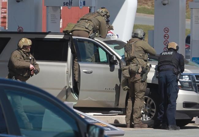 RCMP officers prepare to take a person into custody at a gas station in Enfield, N.S. on Sunday April 19, 2020. A suspect in an active shooter investigation is in custody in Nova Scotia, with police saying several people were harmed before a man wearing police clothing was arrested. Gabriel Wortman was arrested by the RCMP at the Irving Big Stop in Enfield, N.S., about 35 km from downtown Halifax. (THE CANADIAN PRESS/Tim Krochak)