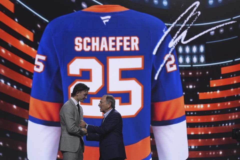 Matthew Schaefer, left, stands with NHL commissioner Gary Bettman after being drafted by the New York Islanders during the NHL hockey draft Friday, June 27, 2025, in Los Angeles. (AP Photo/Damian Dovarganes)