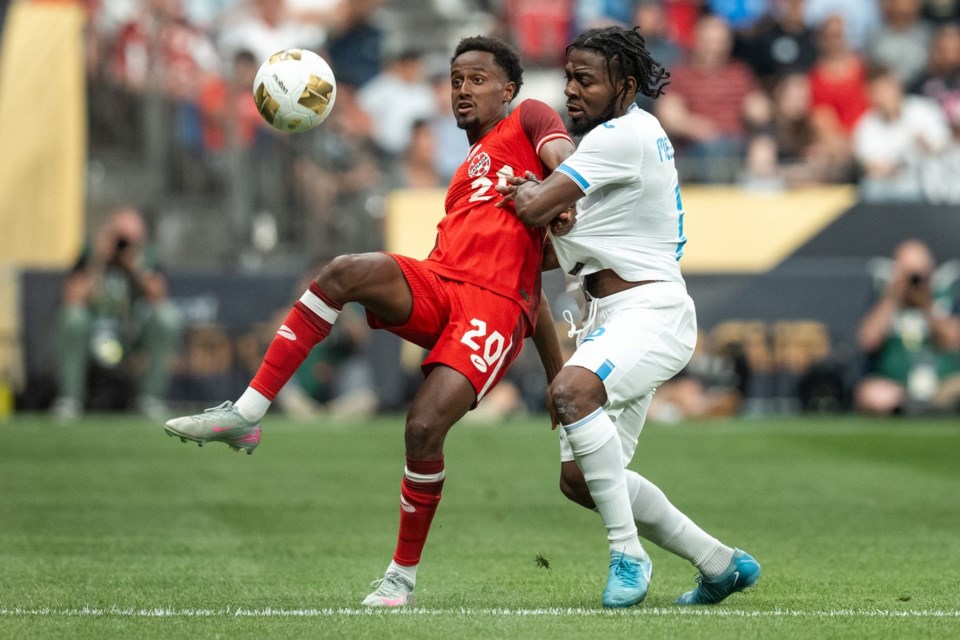 Canada's Ali Ahmed (20) and Honduras' Cristopher Melendez, right, vie for the ball during the first half of a CONCACAF Gold Cup soccer match in Vancouver, on Tuesday, June 17, 2025. THE CANADIAN PRESS/Ethan Cairns