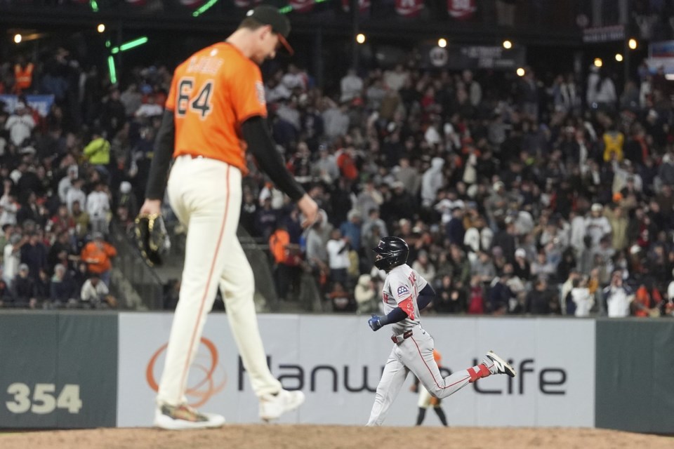 San Francisco Giants pitcher Sean Hjelle, foreground, reacts after a home run by Boston Red Sox's Ceddanne Rafaela, bottom, during the sixth inning of a baseball game in San Francisco, Friday, June 20, 2025. (AP Photo/Jeff Chiu)