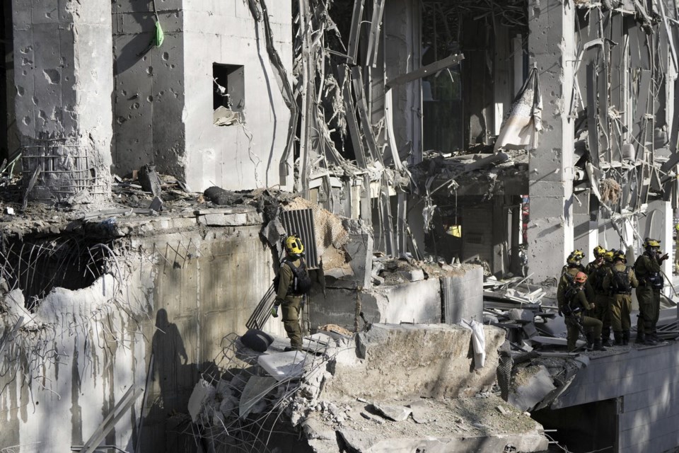 Rescue workers and military personnel inspect the site of a direct hit from an Iranian missile strike in Ramat Gan, Israel, Thursday, June 19, 2025. (AP Photo/Oded Balilty)