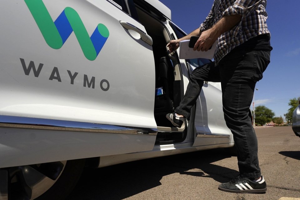 FILE - A Waymo minivan arrives to pick up passengers for an autonomous vehicle ride, April 7, 2021, in Mesa, Ariz. (AP Photo/Ross D. Franklin, File)