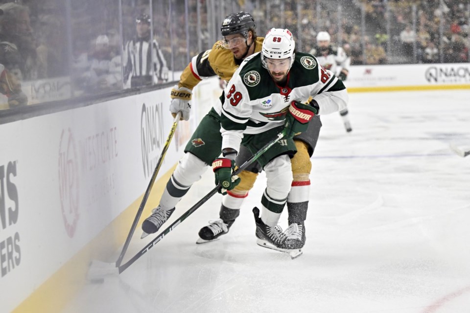 FILE - Vegas Golden Knights center Brett Howden (21) and Minnesota Wild center Frederick Gaudreau (89) battle for the puck during the first period of Game 5 of a first-round NHL hockey playoff series on April 29, 2025, in Las Vegas. (AP Photo/David Becker, File)