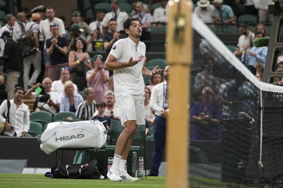 Taylor Fritz of the U.S. reacts after the first round men's single match against Giovanni Mpetshi Perricard of France was suspended at the Wimbledon Tennis Championships in London, Monday, June 30, 2025. (AP Photo/Kin Cheung)