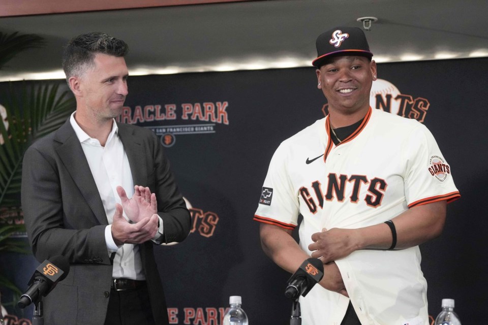 San Francisco Giants' Rafael Devers, right, smiles next to President of Baseball Operations Buster Posey at a news conference before a baseball game between the Giants and the Cleveland Guardians in San Francisco, Tuesday, June 17, 2025. (AP Photo/Jeff Chiu)