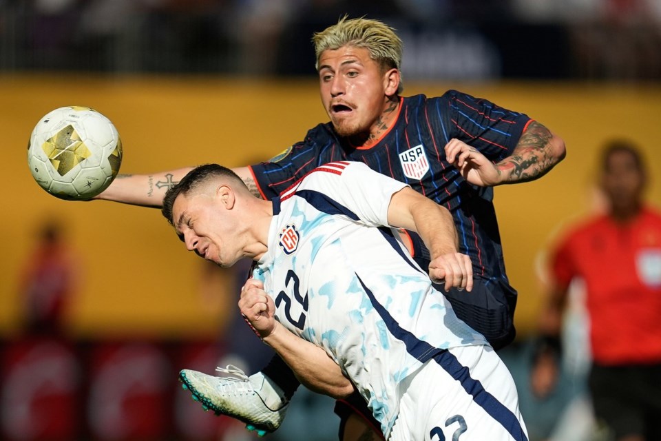 Costa Rica midfielder Carlos Andrei Mora Montoya (22) and United States midfielder Diego Angel Luna, right, battle for possession of the ball during the first half of a CONCACAF Gold Cup quarterfinals soccer match Sunday, June 29, 2025, in Minneapolis. (AP Photo/Abbie Parr)