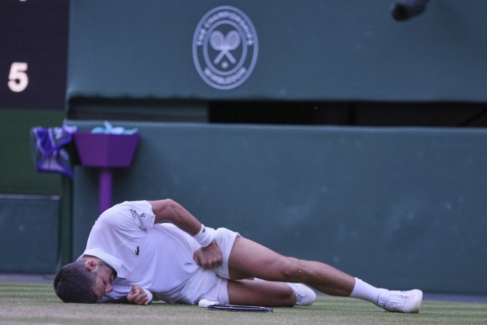 Serbia's Novak Djokovic reacts after slipping and falling when attempting a return to Italy's Flavio Cobolli during a quarterfinal men's singles match at the Wimbledon Tennis Championships in London, Wednesday, July 9, 2025. (AP Photo/Kin Cheung)