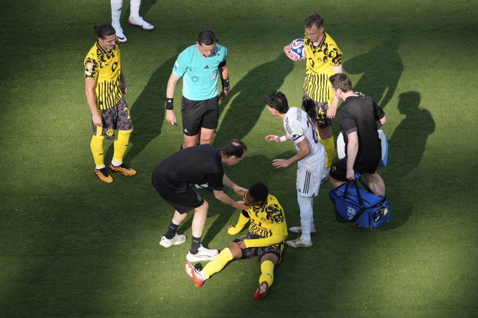 Borussia Dortmund's Julien Duranville, bottom, receives medical treatment during the Club World Cup quarterfinal soccer match between Real Madrid and Borussia Dortmund in East Rutherford, N.J., Saturday, July 5, 2025. (AP Photo/Pamela Smith)