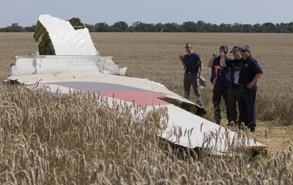FILE - Australian and Dutch investigators examine a piece of the Malaysia Airlines Flight 17 plane, near the village of Hrabove, Russian-controlled Donetsk region of eastern Ukraine in Aug. 1, 2014. (AP Photo, File)