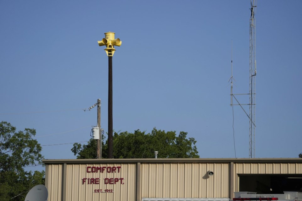 An emergency siren is visible on top of the Comfort Volunteer Fire Department in Comfort, Texas on Thursday, July 10, 2025. (AP Photo/Ashley Landis)