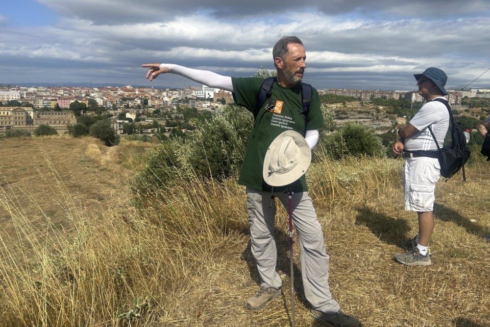 Jesuit Josep LluÌs Iriberri points toward Manresa, where his group of pilgrims will conclude the Ignatian Way pilgrimage, in Spain, Wednesday, July 9, 2025. (AP Photo/Joseph Wilson)
