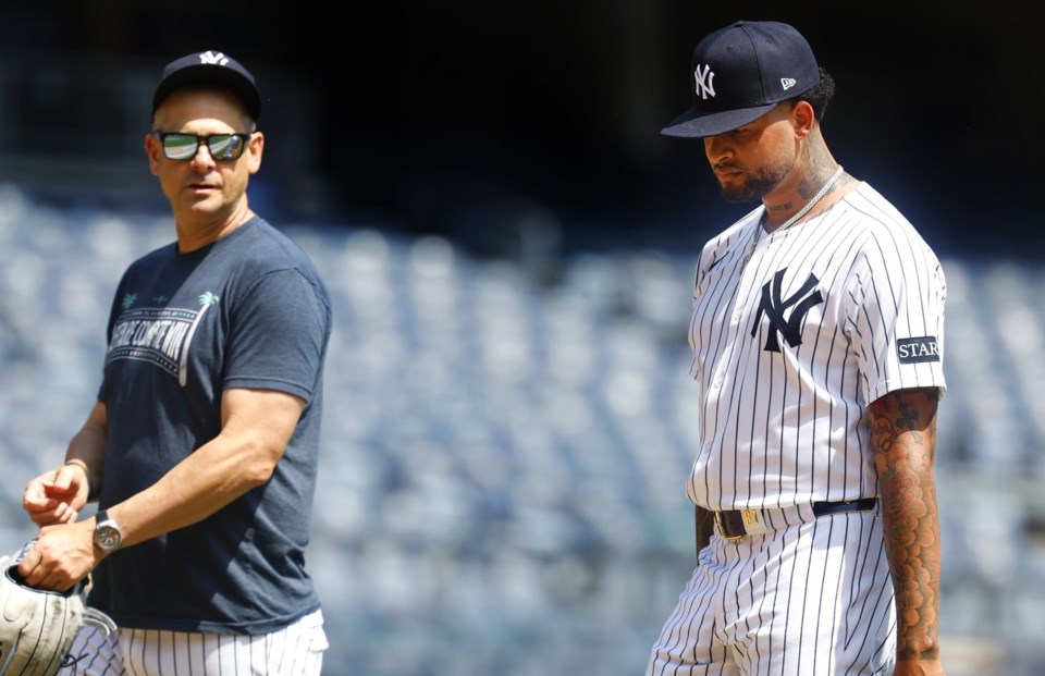 New York Yankees' manager Aaron Boone and Luis Gil talk during live batting practice before a baseball game against the Baltimore Orioles, Saturday, June 21, 2025, in New York. (AP Photo/Noah K. Murray)