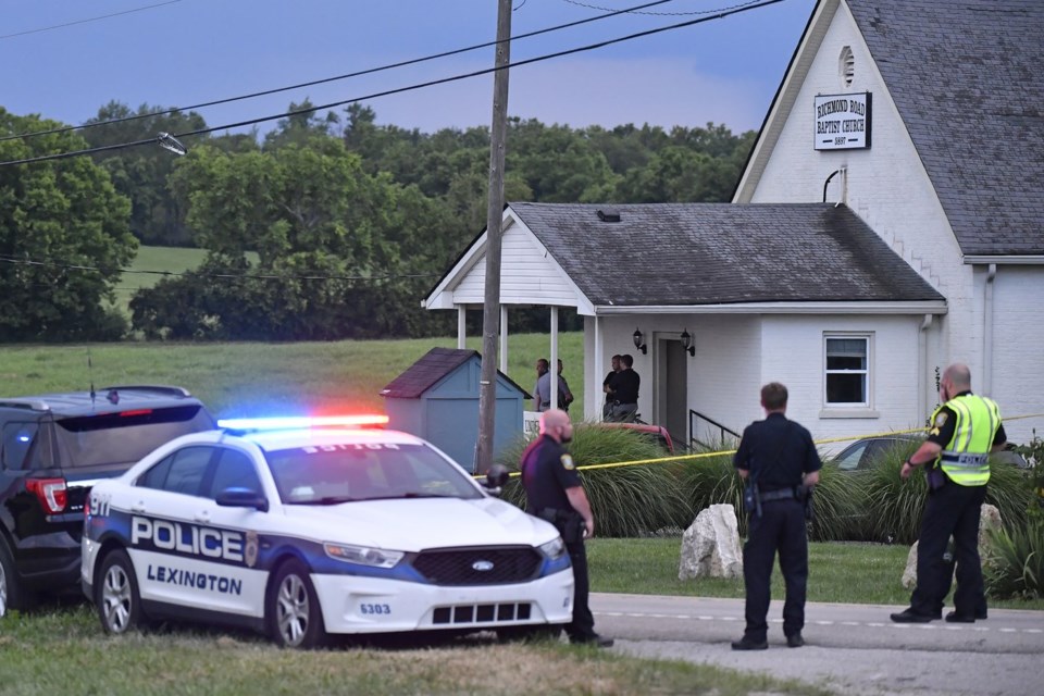 Police stand at the front of the Richmond Road Baptist Church as other officers maintain a perimeter following a shooting at the church in Lexington, Ky., Sunday, July 13, 2025. (AP Photo/Timothy D. Easley)