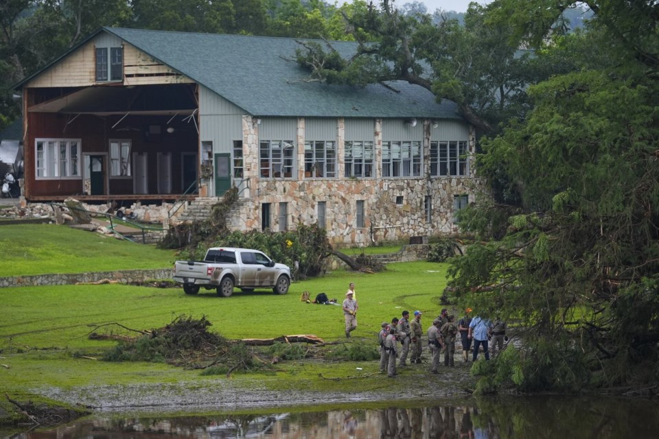 Officials search on the grounds of Camp Mystic along the banks of the Guadalupe River after a flash flood swept through the area Sunday, July 6, 2025, in Hunt, Texas. (AP Photo/Julio Cortez)