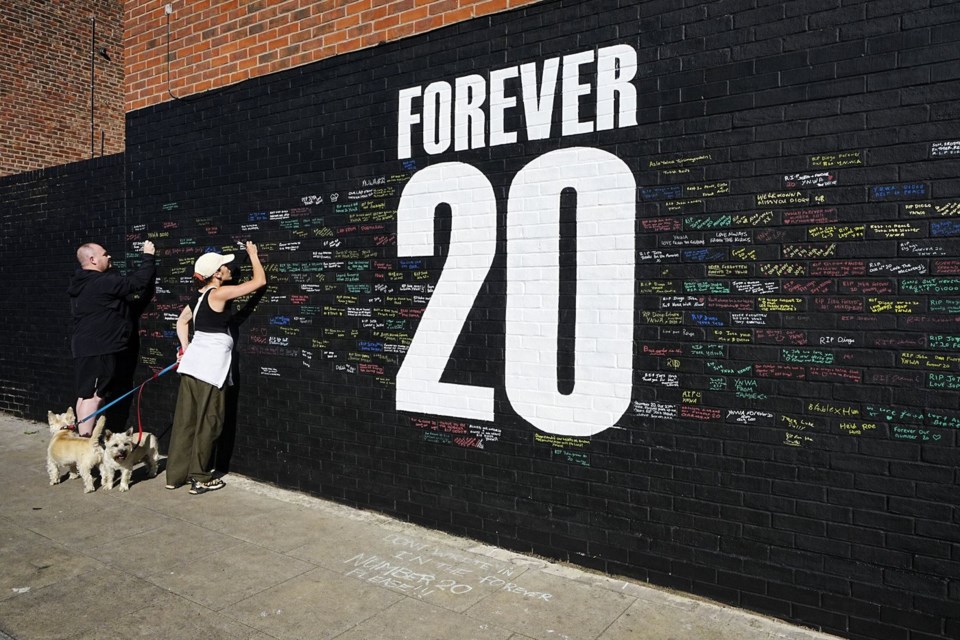 Fans sign a mural in memory of late Liverpool player Diogo Jota, on Sybil Road near Anfield in Liverpool, England, Tuesday, July 8, 2025. (Peter Byrne/PA via AP)