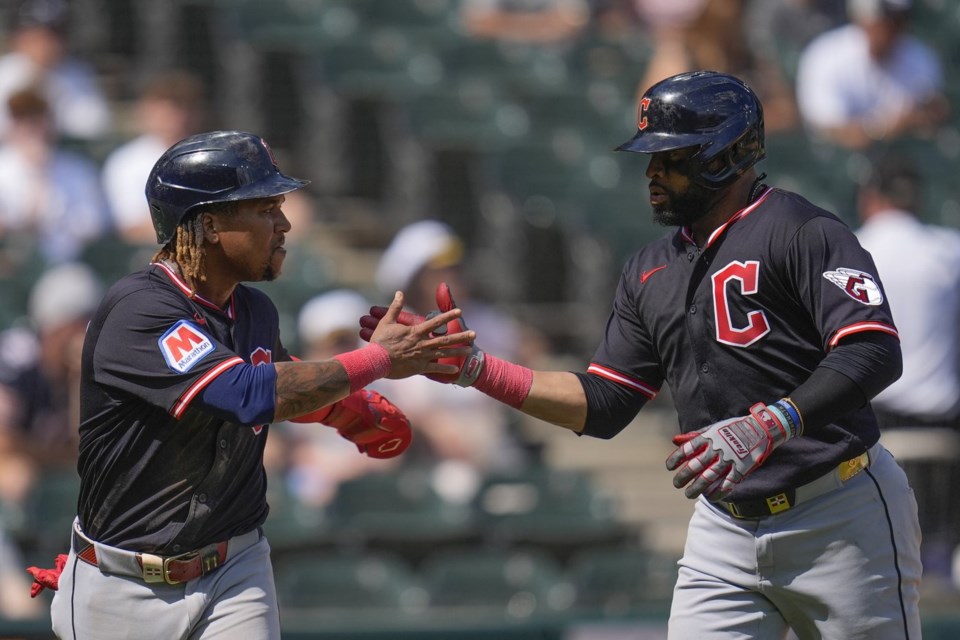 Cleveland Guardians' Carlos Santana, right, celebrates with José Ramírez, left, after hitting a two-run home run during the sixth inning of the first baseball game of a doubleheader against the Chicago White Sox, Friday, July 11, 2025, in Chicago. (AP Photo/Erin Hooley)