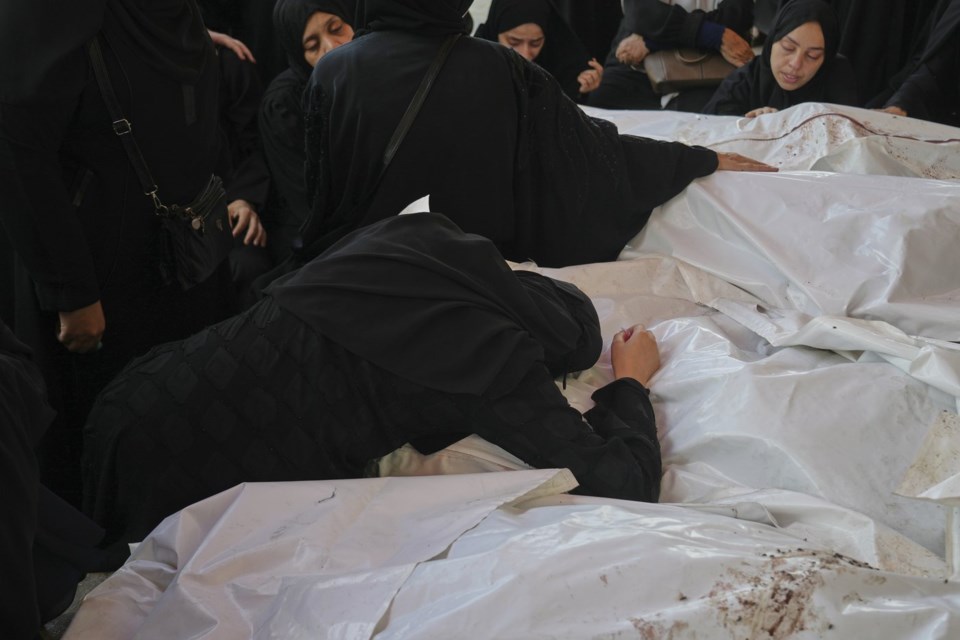 Mourners attend the funeral of their relatives who were killed in an Israeli bombardment, in Deir al-Balah, Gaza Strip, Saturday, July 12, 2025. (AP Photo/Abdel Kareem Hana)