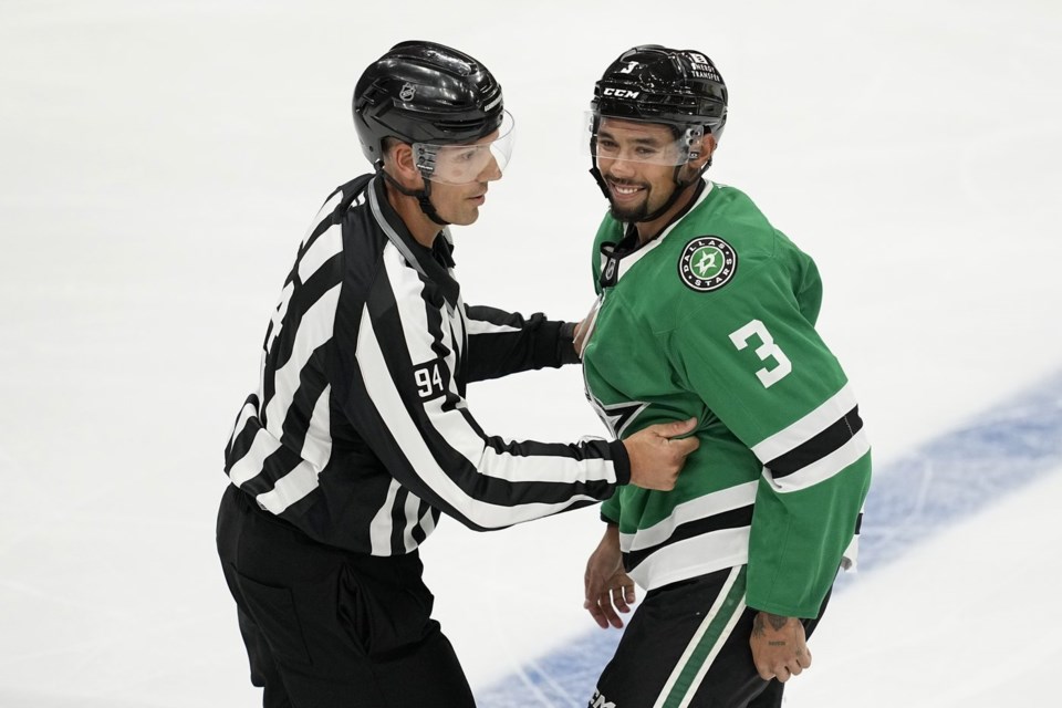 FILE - Linesman Bryan Pancich (94) holds Dallas Stars' Matt Dumba (3) back after a brief scuffle with Minnesota Wild players in the second period of a preseason NHL hockey game, Sept. 25, 2024, in Dallas. (AP Photo/Tony Gutierrez, File)