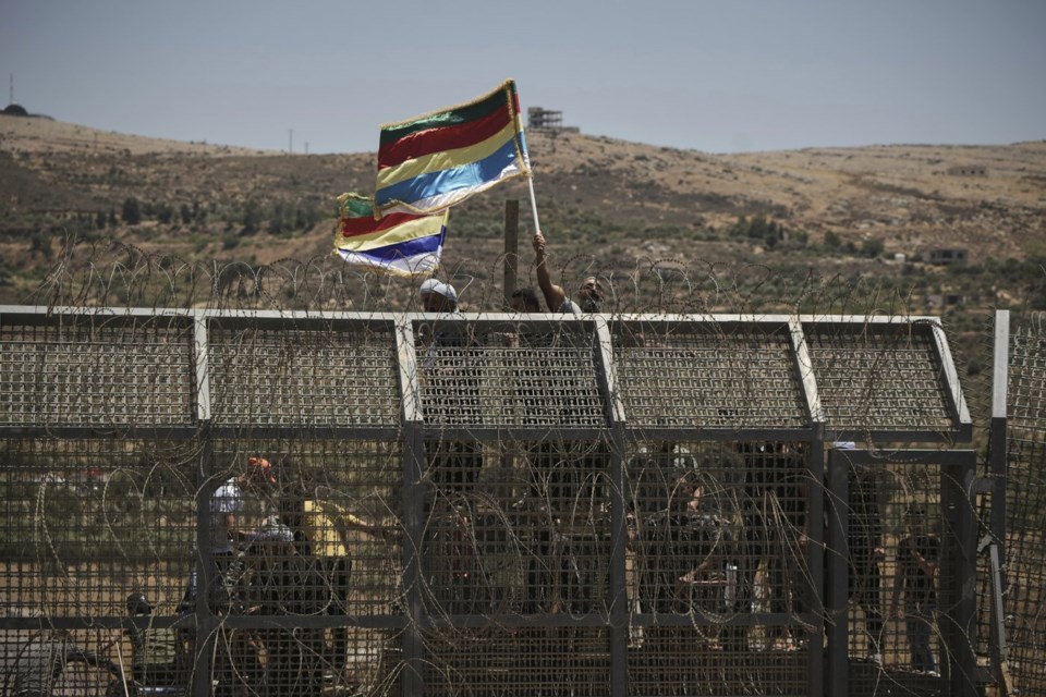Syrian Druze protest near the Israeli-Syrian border, as seen from the town of Majdal Shams in the Israeli-controlled Golan Heights, Wednesday, July 16, 2025, amid the ongoing clashes between Syrian government forces and Druze armed groups in the southern Syrian city of Sweida. (AP Photo/Leo Correa)