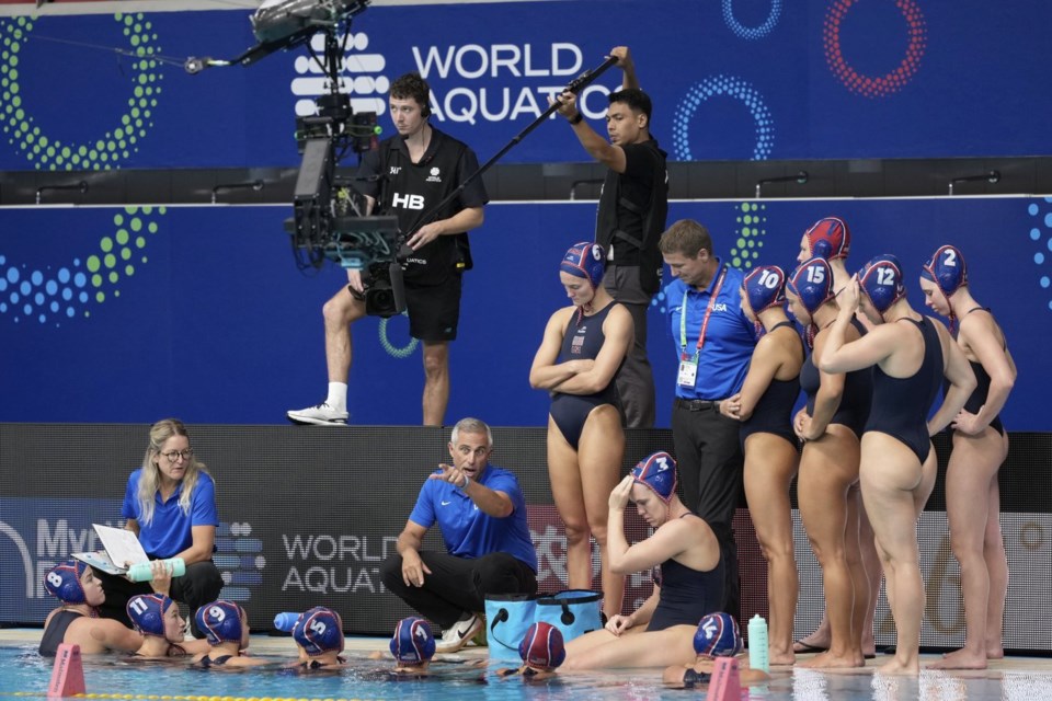 United States head coach Adam Krinkorian, speaks with the players during the women's water polo preliminary round against Argentina at the World Aquatics Championships in Singapore, Tuesday, July 15, 2025. (AP Photo/Vincent Thian)