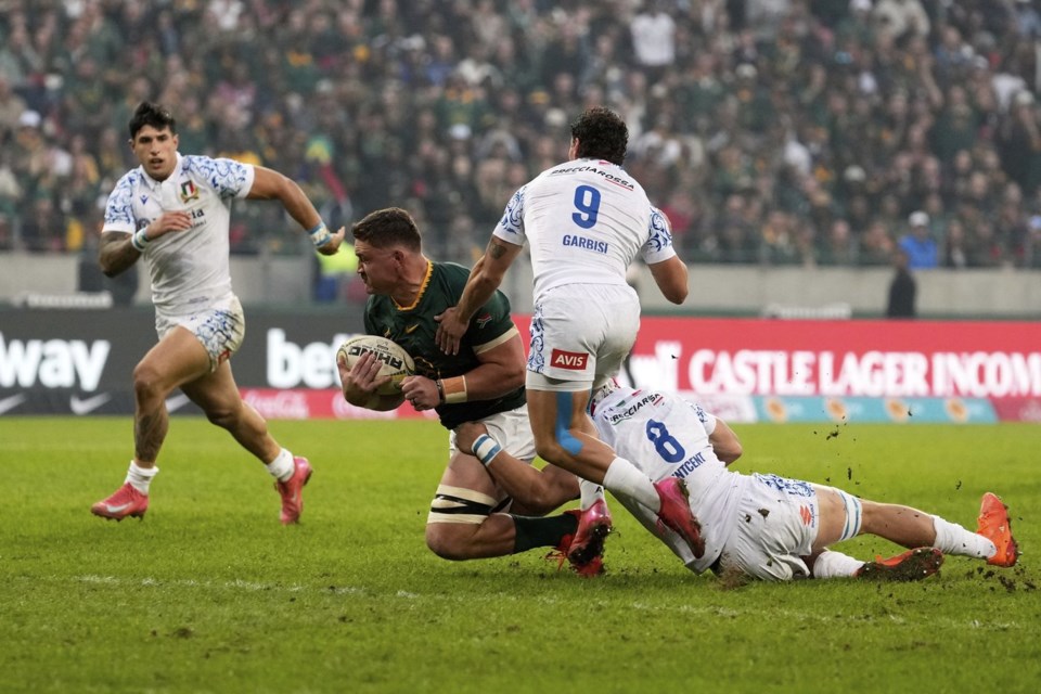 South Africa's Jasper Wiese, centre, is tackled by Italy's Ross Vintcent during a rugby championship test match between South Africa and Italy, at the Nelson Mandela Bay stadium in Gqeberha, South Africa, Saturday, July 12, 2025. (AP Photo/Themba Hadebe)