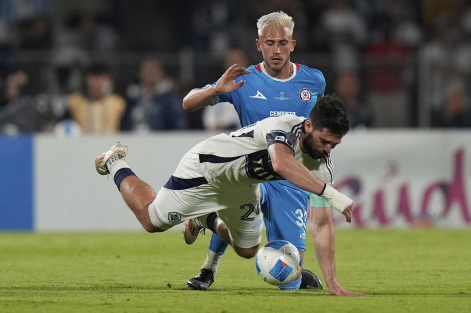 Brian White of Canada's Vancouver Whitecaps, front, is challenged by Gonzalo Piovi of Mexico's Cruz Azul during the CONCACAF Champions Cup final soccer match in Mexico City, Sunday, June 1, 2025. (AP Photo/Fernando Llano)