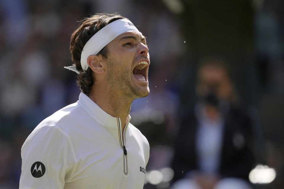 Taylor Fritz of the U.S. celebrates winning the men's singles quarter final match against Karen Khachanov of Russia at the Wimbledon Tennis Championships in London, Tuesday, July 8, 2025.(AP Photo/Kin Cheung)