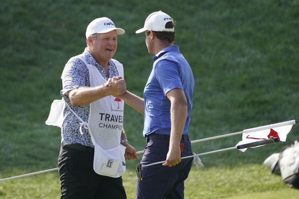 FILE - Harris English, right, celebrates a birdie on the 18th green with his caddie during the final round of the Travelers Championship golf tournament at TPC River Highlands, Sunday, June 27, 2021, in Cromwell, Conn. (AP Photo/John Minchillo, File)