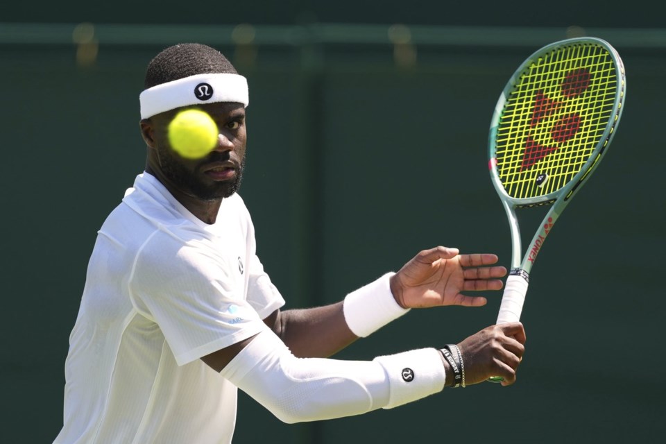 Frances Tiafoe of the U.S. returns the ball to Elmer Moller of Denmark during their first round men's single match at the Wimbledon Tennis Championships in London, Monday, June 30, 2025. (AP Photo/Kirsty Wigglesworth)