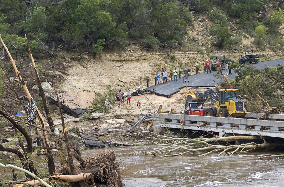 Crews work to clear debris from the Cade Loop bridge along the Guadalupe River on Saturday, July 5, 2025, in Ingram, Texas. (AP Photo/Rodolfo Gonzalez)