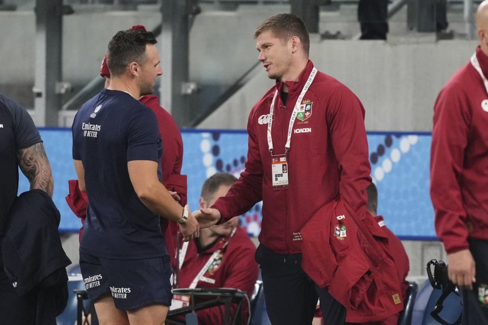 Owen Farrell, right, a replacement for the British & Irish Lions tour shakes hands with referee Paul Williams ahead of the game against the Waratahs in Sydney, Australia, Saturday, July 5, 2025. (AP Photo/Mark Baker)