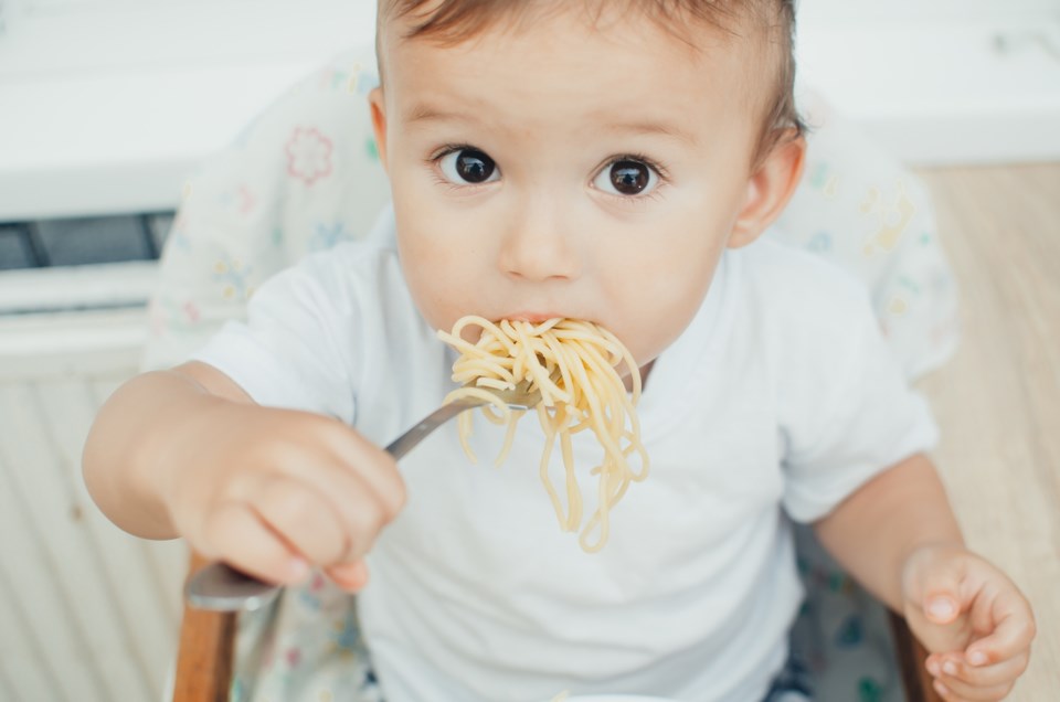 baby eating noodles stock