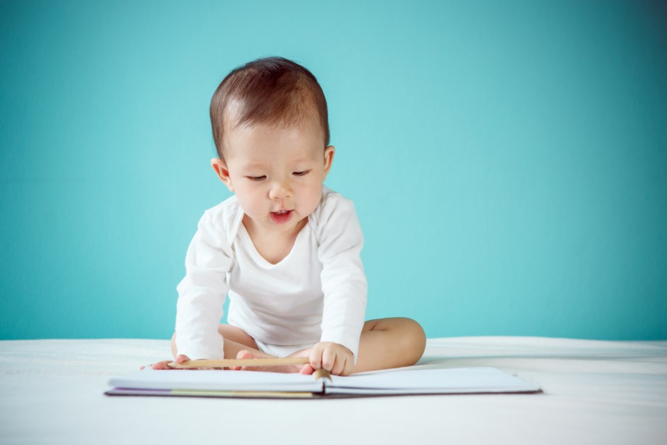 Baby reading book shutterstock