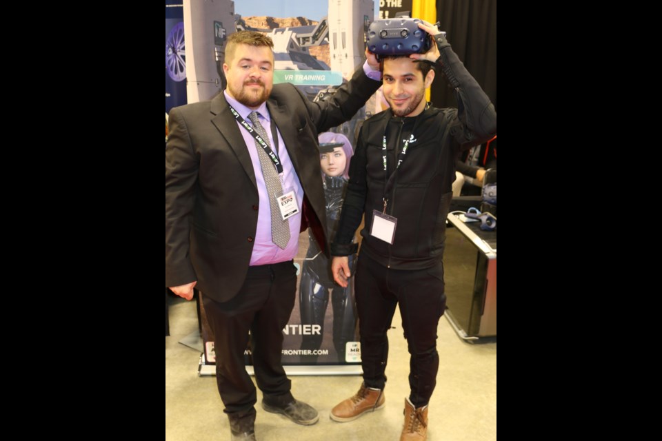 Next Frontier Corp. CEO Jason Michaud of Cochrane (left) and technology officer Jawad El Houssine demonstrate a virtual reality headset along with a virtual reality bodysuit. (Len Gillis photo)