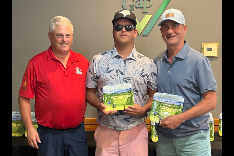 Hayden Foulds, middle, and his dad David, right, recieve accolades after Hayden finished second in the the B1 men’s division at the International Sports Promotion Society HANDA Canadian Blind Golf Open Championship.