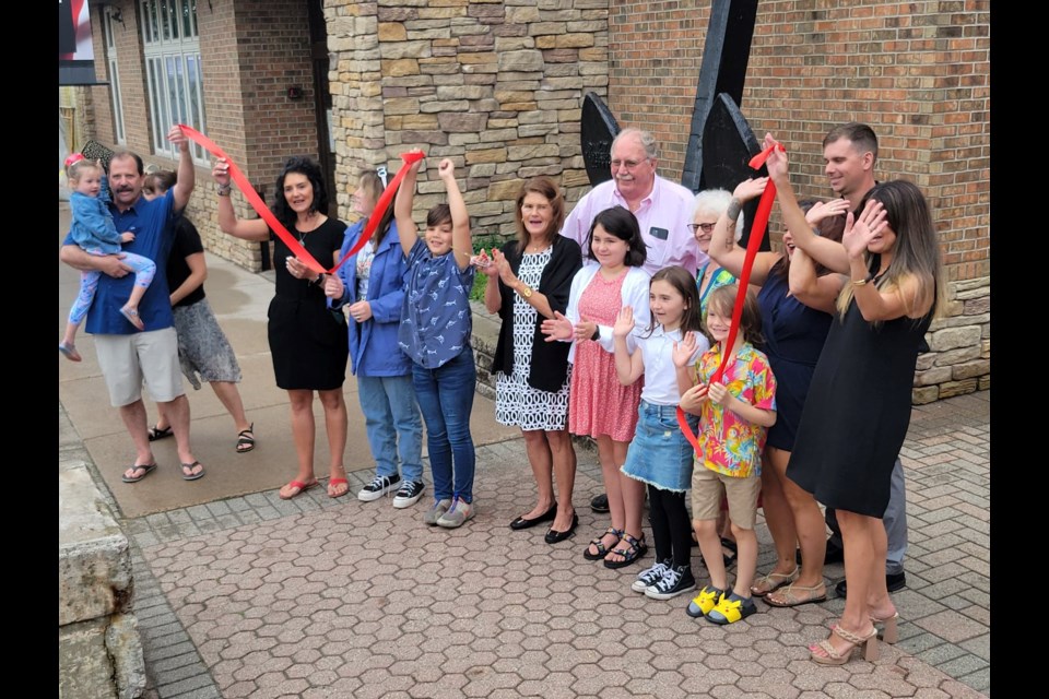 Reenie Butler Calery and family cut the red ribbon at the official renaming of 524 Ashmun to Ronald J. Calery Community Action Center on Monday, Aug. 1 