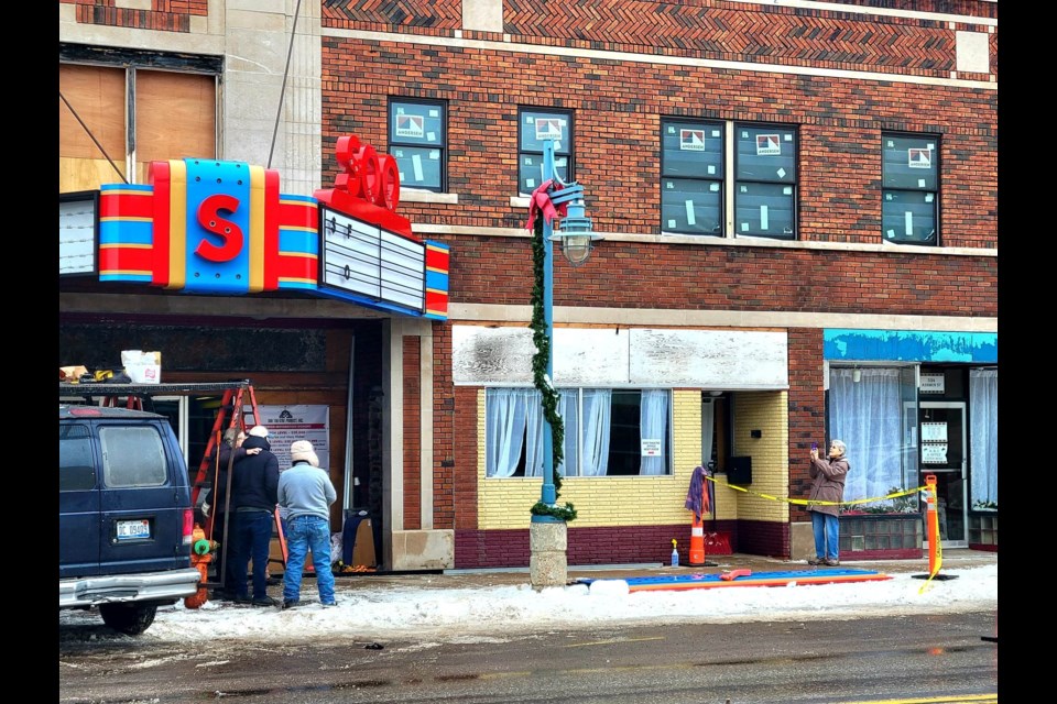 Soo Theatre Executive Director Colleen Arbic takes a picture of Chalou Designs hanging the theatre's newly renovated 1940 marquee on Jan. Saturday, 21, 2023 