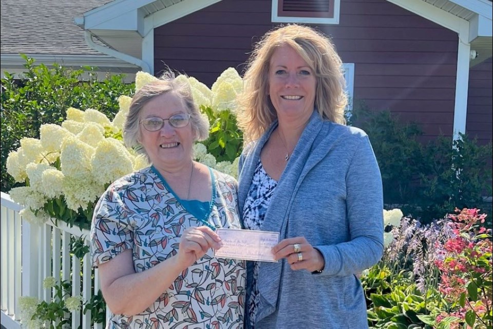 Sheri Ailing presents $1,315 check to Hospice of the EUP Director Tracey Holt after donating more than $20,000 to Hospice of the EUP and MyMichigan Medical Center Sault Road to Recovery, since losing her husband to lung cancer in 2013