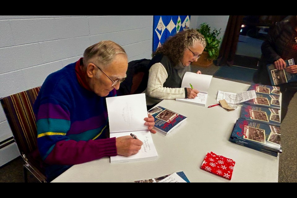 Bernie Arbic and Collette Coullard autograph books at the event Tuesday evening.
