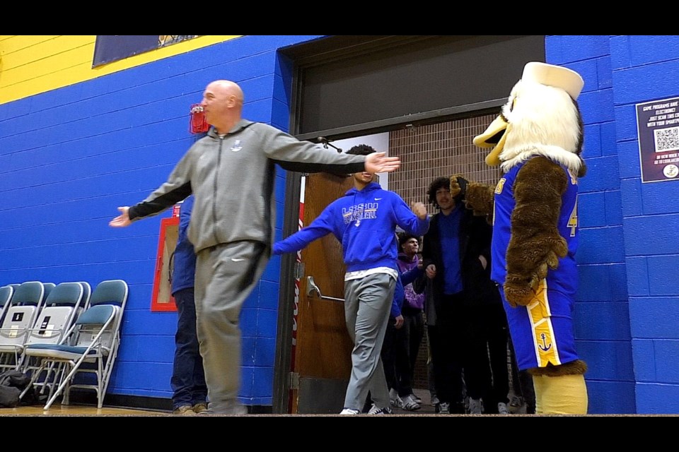 Coach Steve Hettinga walks into the Bud Cooper Gymnasium with his team.