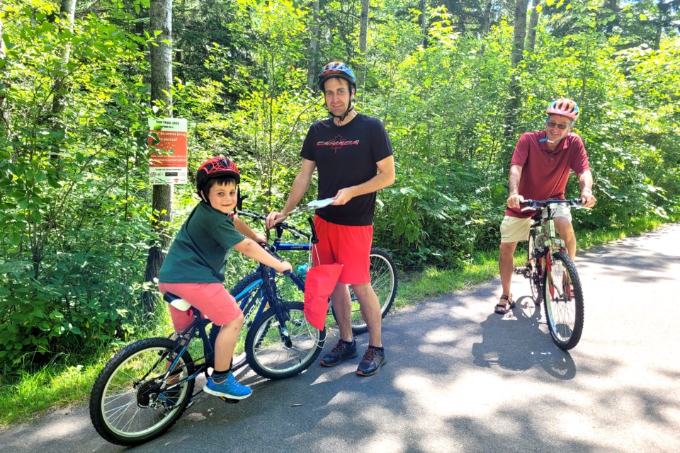 Quinton, Matthew and Bob Monarch find a riddle to answer on the Finn Hill leg of the John Rowswell Hub Trail. This is the second year Quinton and Matthew have participated in the challenge.