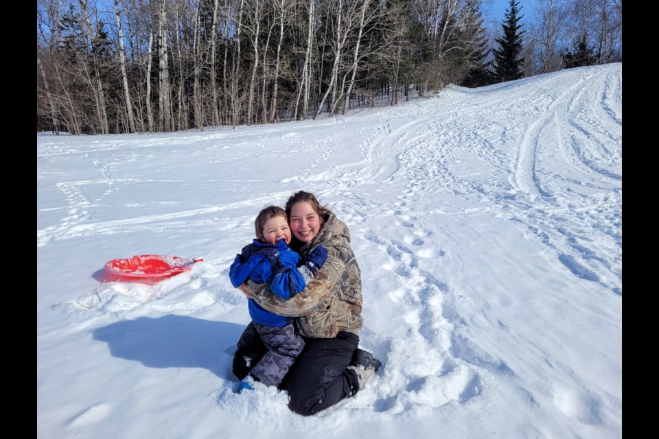 Daniel Beaudoin, soon to be three, and his mom, Tara, enjoy some sliding on the hill at Fort Creek Conservation Area on Friday morning.