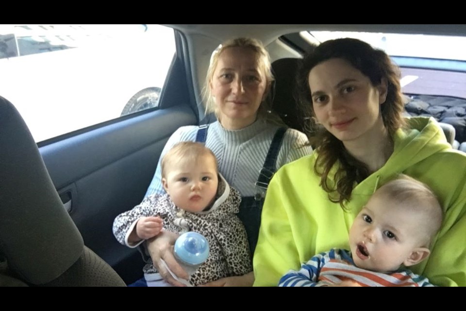 Liliia Tsiupka with her daughters Nadiia Uschenko (on her lap) and Oksana Kindrativ and grandson Dem'yan rest in a taxi on their way back to their hotel from the Canadian Consulate in Warsaw after fleeing the fighting in Ukraine. 